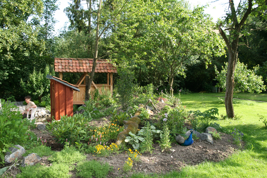 Pfau und Mensch genießen den Garten des Hotels Ebner